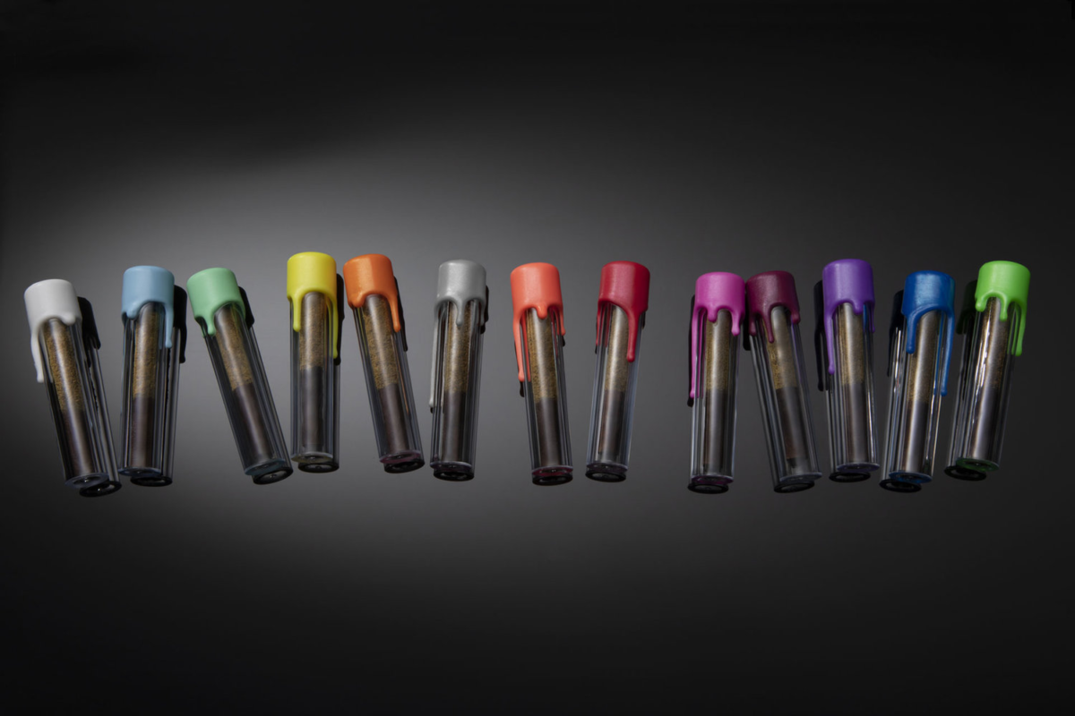 A collection of six vibrant pens displayed against a sleek black background, showcasing their diverse colors and designs.